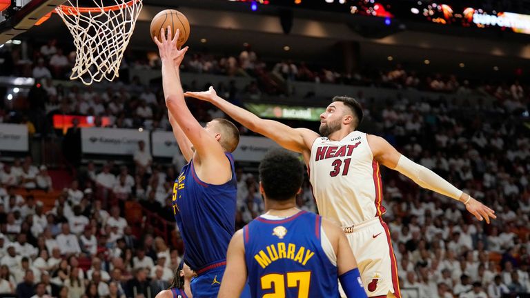 Denver Nuggets center Nikola Jokic (15) drives to the basket as Miami Heat guard Max Strus (31) attempts to defend.