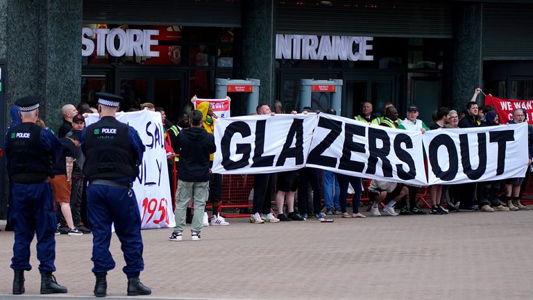 La  policía observa cómo los fanáticos del Manchester United se reúnen frente a Old Trafford para protestar contra la propiedad del club.  Imagen fecha: martes 27 de junio de 2023.