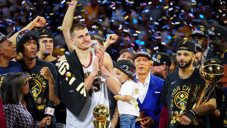 Denver Nuggets center Nikola Jokic, center left, celebrates with teammates after winning their first NBA title