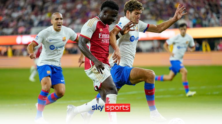 Arsenal FC midfielder Bukayo Saka, center, and FC Barcelona forward Ferran Torres, right, vie for the ball during the first half of a Champions Cup soccer match, Wednesday, July 26, 2023, in Inglewood, Calif. (AP Photo/Ashley Landis)