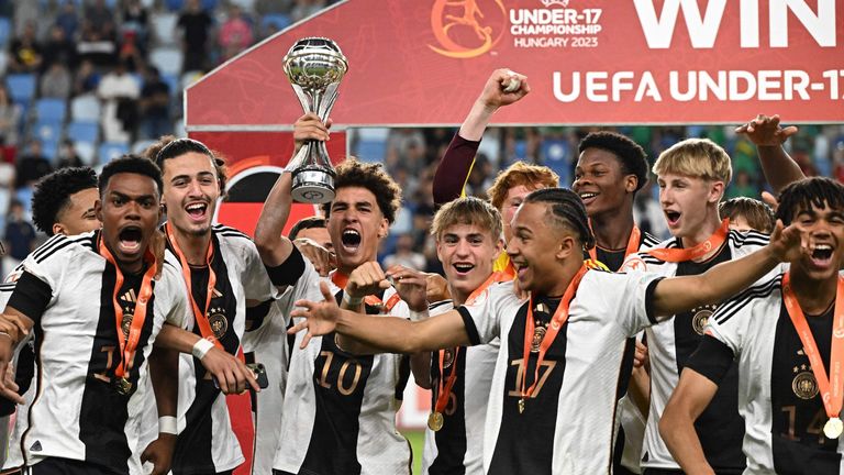 Germany's midfielder Noah Darvich (C) and his teammates celebrate with the trophy after winning the UEFA Under 17 final football match between Germany and France at the Hidegkuti Nandor Stadium in Budapest, Hungary on June 2, 2023.