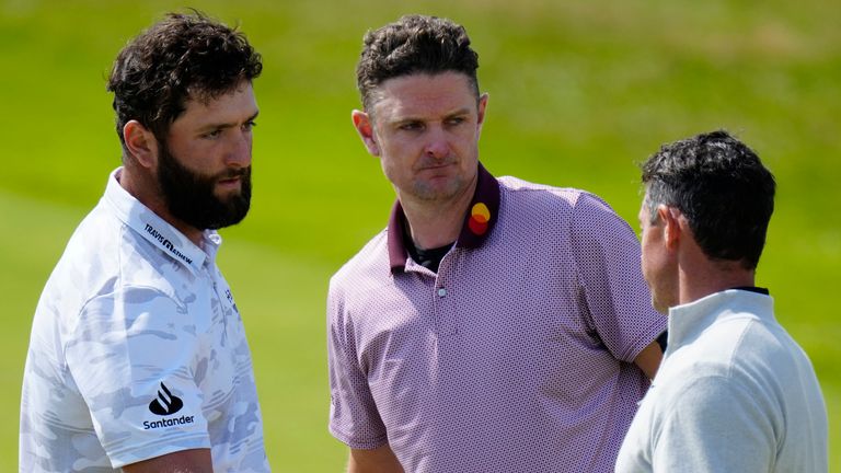 Spain's Jon Rahm, left shakes hands with Northern Ireland's Rory McIlroy, right as England's Justin Rose looks on after they completed their round on the 18th green during the second day of the British Open Golf Championships at the Royal Liverpool Golf Club in Hoylake, England, Friday, July 21, 2023. (AP Photo/Jon Super) 
