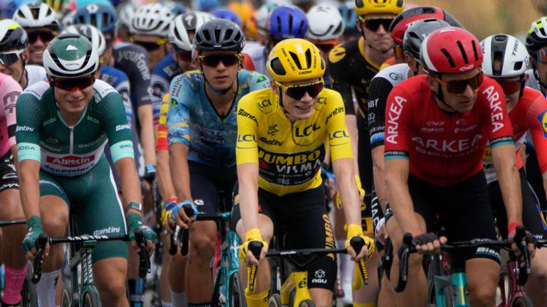 Denmark's Jonas Vingegaard, wearing the overall leader's yellow jersey, Slovenia's Tadej Pogacar, wearing the best young rider's white jersey, right, and Belgium's Jasper Philipsen, wearing the best sprinter's green jersey, center left, rides in the pack during the twenty-first stage of the Tour de France cycling race over 115 kilometers (71.5 miles) with start in Saint-Quentin-en-Yvelines and finish on the Champs Elysees in Paris, France, Sunday, July 23, 2023. (AP Photo/Daniel Cole)