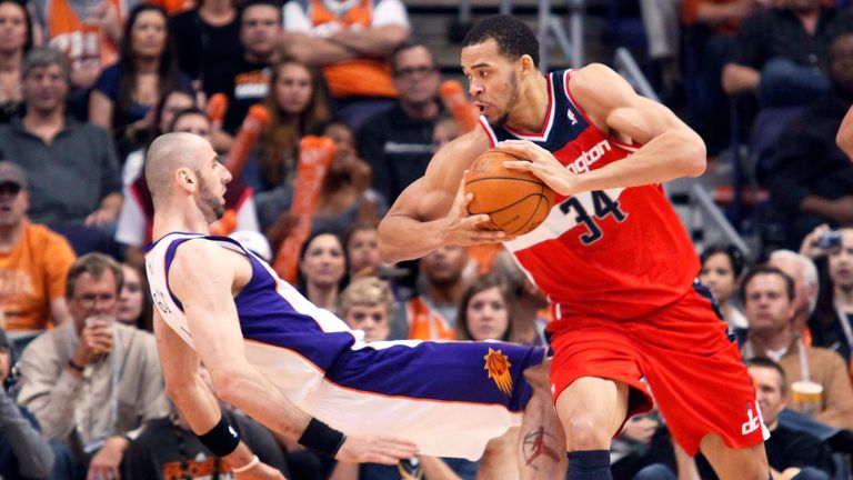 Phoenix Suns center Marcin Gortat falls backward to the floor as Washington Wizards center JaVale McGee is called for a charge