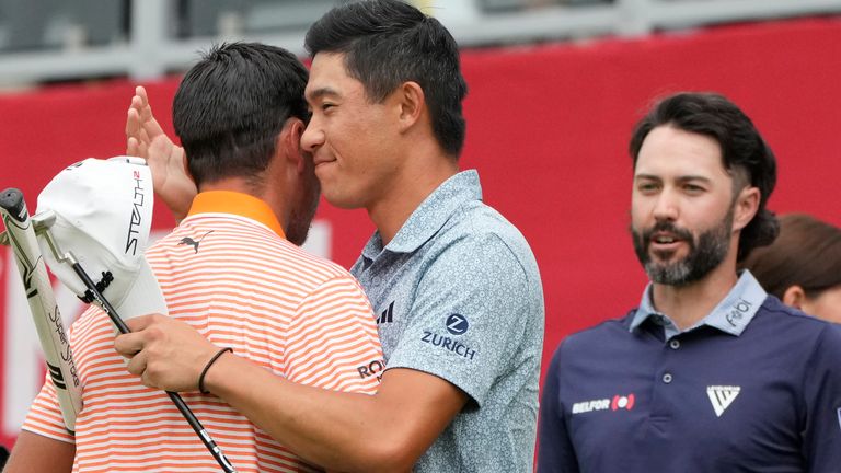 Rickie Fowler, left, is hugged by Collin Morikawa, center, and Adam Hadwin after a playoff hole on the 18th green during the final round of the Rocket Mortgage Classic golf tournament at Detroit Country Club, Sunday, July 2, 2023, in Detroit. (AP Photo/Carlos Osorio)
