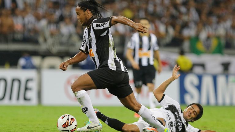 Ronaldinho, left, of Brazil's Atletico Mineiro fights for the ball with Wilson Osmar Pittoni, right,of Paraguay's Olimpia during the Copa Libertadores final soccer match in Belo Horizonte, Brazil, Wednesday, July 24, 2013. 