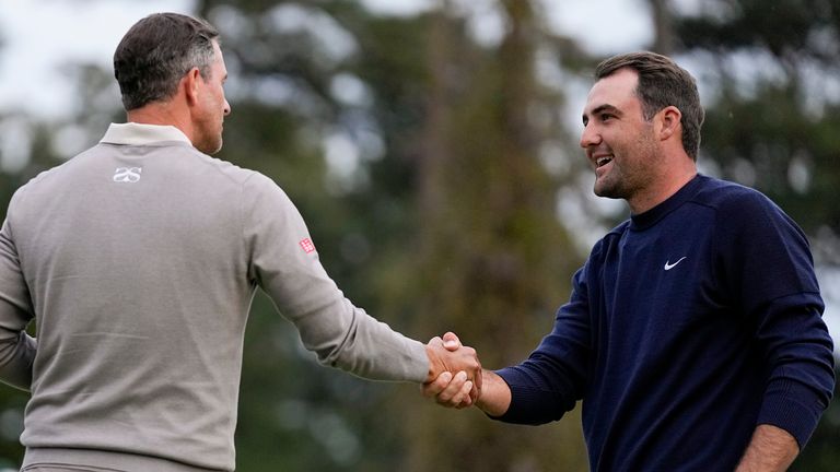 Scottie Scheffler, right, shakes hands with Adam Scott, of Australia, on the 18th green during the second round at the Masters golf tournament on Friday, April 8, 2022, in Augusta, Ga. (AP Photo/Robert F. Bukaty) 