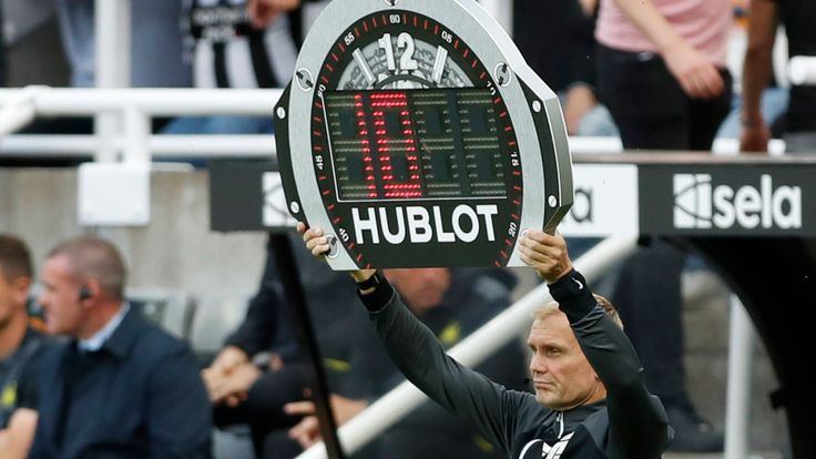 Fourth official Graham Scott holds up a sign indicating ten minutes of added time in the first half during the English Premier League soccer match between Newcastle and Aston Villa at St. James' Park in Newcastle, England, Saturday, Aug. 12, 2023. Newcastle won 5-1. (AP Photo/Steve Luciano)