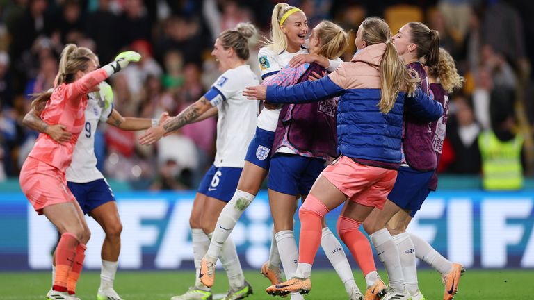 Chloe Kelly celebrates with teammates after scoring her team's fifth and winning penalty