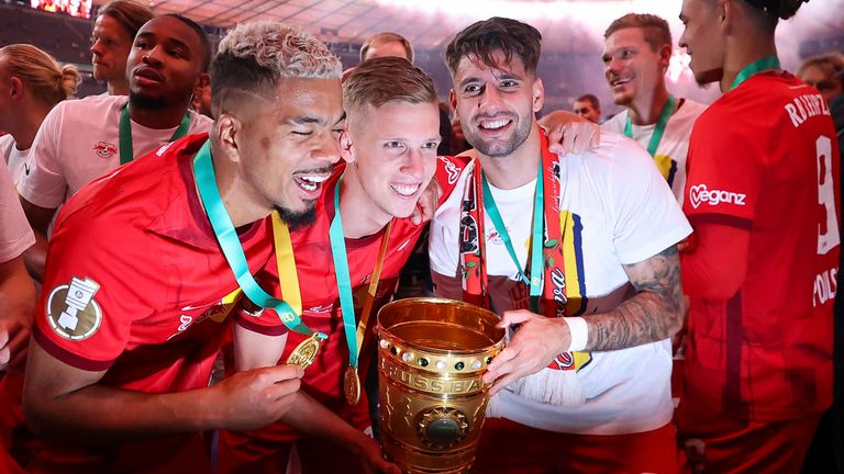 03 June 2023, Berlin: Soccer: DFB Cup, final, RB Leipzig - Eintracht Frankfurt at the Olympiastadion. Leipzig's players around Benjamin Henrichs (l-r), Dani Olmo and Dominik Szoboszlai cheer with the cup.