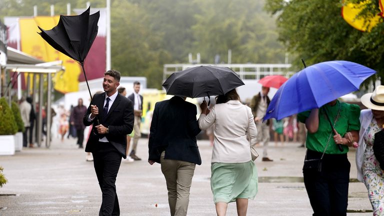 Racegoers at Goodwood battle wet and windy conditions 