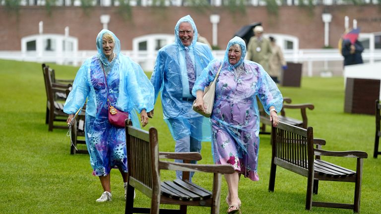 Racegoers shelter from the rain on day two of the Qatar Goodwood Festival