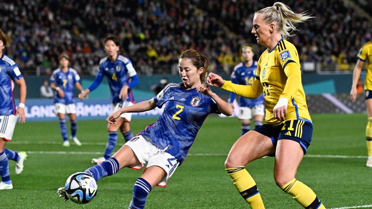Japan's Risa Shimizu fights off Sweden's Stina Blackstenius for a shot at goal