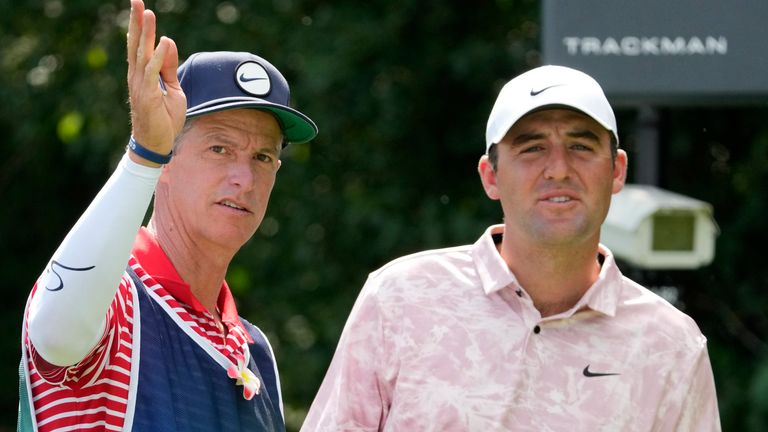 Caddie Diego Origel, from Chicago Heights, Ill., talks about the second fairway with Scottie Scheffler during the first round of the BMW Championship golf tournament, Thursday, Aug. 17, 2023, in Olympia Fields, Ill. (AP Photo/Charles Rex Arbogast)