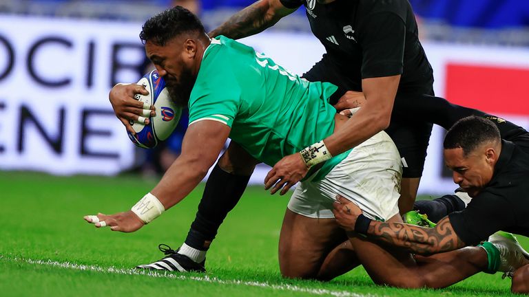 Ireland's Bundee Aki, left, scores a try during the Rugby World Cup quarterfinal match between Ireland and New Zealand at the Stade de France in Saint-Denis, near Paris, Saturday, Oct. 14, 2023. (AP Photo/Aurelien Morissard)