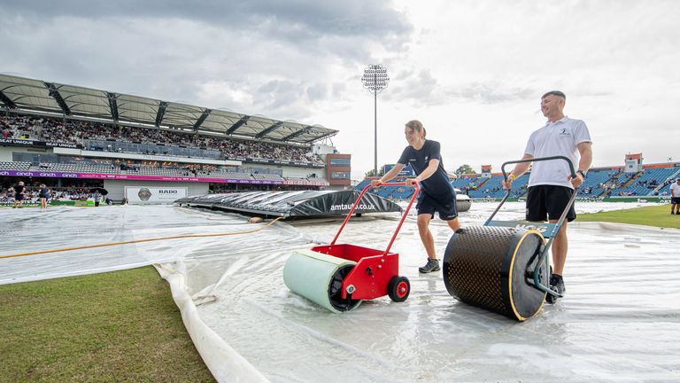 Jasmine Nicholls helps to put the covers on at Headingley during a rain delay