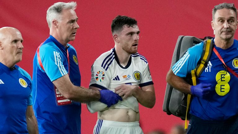 Scotland&#39;s Andrew Robertson leaves the pitch holding his arm following a collision with Spain goalkeeper Unai Simon during the Euro 2024 qualifier