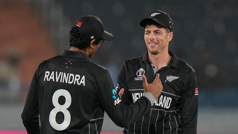 New Zealand's Mitch Santner celebrates with teammate Rachin Ravindra after finishing his bowling spell 