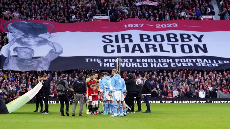 Manchester United fans unfurl a banner paying tribute to the late Sir Bobby Charlton