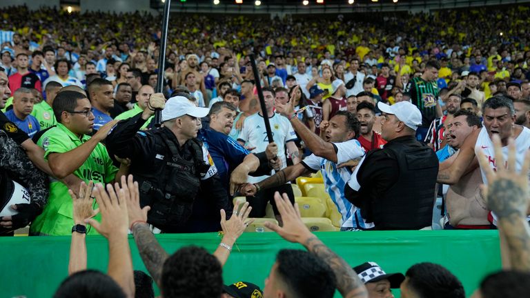 ตำรวจพยายามหยุดการต่อสู้ระหว่างแฟนบอลชาวบราซิลและอาร์เจนติน่าที่ปะทุขึ้นก่อนการแข่งขันฟุตบอลรอบคัดเลือกฟุตบอลโลก 2026 ระหว่างบราซิลและอาร์เจนตินาที่สนามกีฬามาราคานาในเมืองรีโอเดจาเนโร ประเทศบราซิล วันอังคารที่ 21 พ.ย. 2023 (AP ภาพ/ซิลเวีย อิซเกียร์โด้)