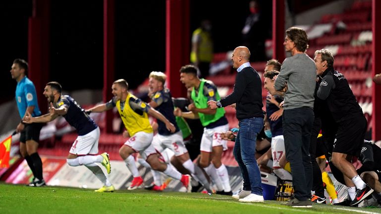 Barnsley manager Gerhard Struber and his players celebrate at the final whistle as Brentford manager Thomas Frank looks on after the Sky Bet Championship match at Griffin Park, London.