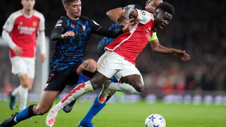 Arsenal's Bukayo Saka, right, competes for the ball with Sevilla's Kike Salas, during the Champions League Group B soccer match between Arsenal and Sevilla at Emirates stadium in London Wednesday, Nov. 8, 2023. (AP Photo/Kirsty Wigglesworth)
