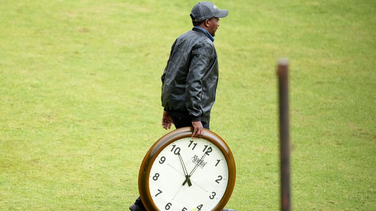 Geezer on a cricket field with a clock (Associated Press)