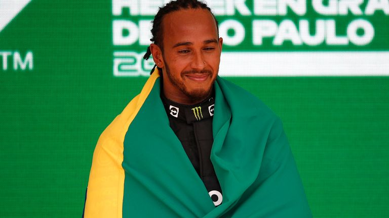 AUT..DROMO JOS.. CARLOS PACE, BRAZIL - NOVEMBER 14: Sir Lewis Hamilton, Mercedes, 1st position, celebrates on the podium with a Brazilian flag during the Brazilian GP at Aut..dromo Jos.. Carlos Pace on Sunday November 14, 2021 in Sao Paulo, Brazil. (Photo by Zak Mauger / LAT Images)