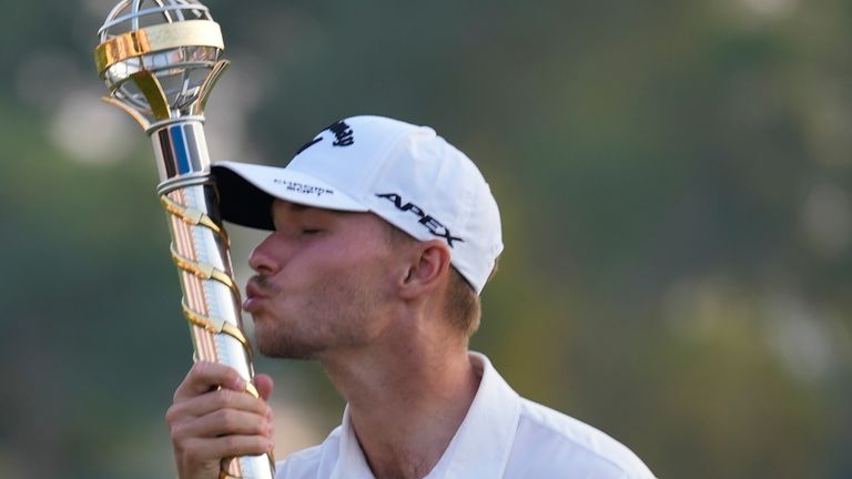 Nicolai Hojgaard of Denmark kisses his trophy after he won the final round of the DP World Tour Championship golf tournament, in Dubai, United Arab Emirates, Sunday, Nov. 19, 2023. (AP Photo/Kamran Jebreili)