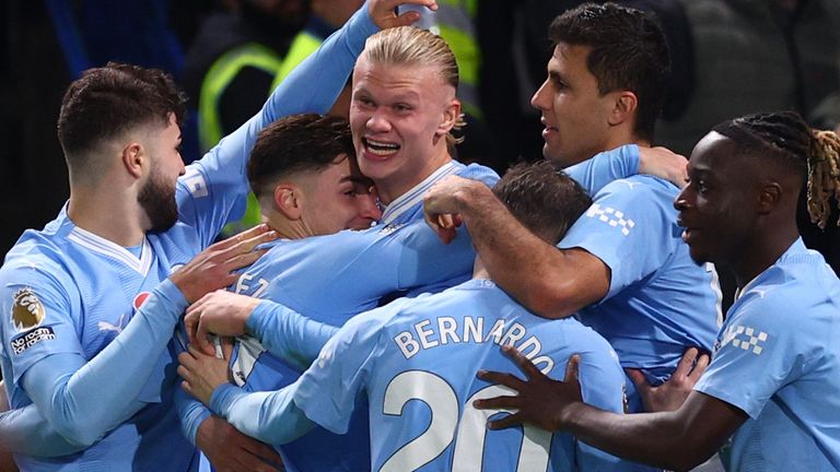 Erling Haaland is mobbed after restoring Man City's lead at Chelsea