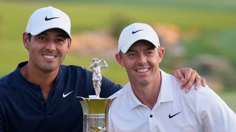 Rory McIlroy of Northern Ireland poses with the Race to Dubai trophy alongside his caddie, Harry Diamond on the 18th hole during the final round of the DP World Tour Championship golf tournament, in Dubai, United Arab Emirates, Sunday, Nov. 19, 2023. (AP Photo/Kamran Jebreili) 