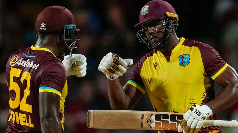 West Indies&#39; batsmen Andre Russell and Rovman Powell celebrate runs during their partnership against England in the first T20 cricket match at Kensington Oval in Bridgetown, Barbados, Tuesday, Dec. 12, 2023. (AP Photo/Ricardo Mazalan)