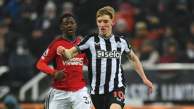 Newcastle United's English midfielder Anthony Gordon runs with the ball during the Premier League football match against Manchester United at St James' Park with Kobbie Mainoo in pursuit