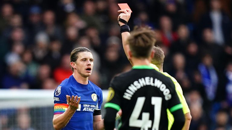 Referee Craig Pawson shows a red card to Chelsea's Conor Gallagher