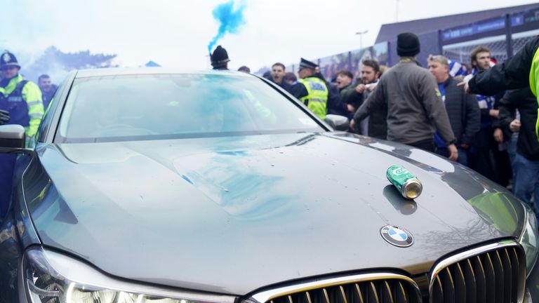 A beer can lands on the bonnet of the car taking Delia Smith to the East Anglian derby
