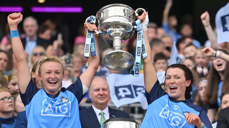 Dublin captain Carla Rowe, left, and teammate Leah Caffrey lift the Brendan Martin Cup after their side's victory in the 2023 TG4 LGFA All-Ireland Senior Championship final