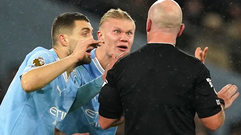 Manchester City players react after referee Simon Hooper stops play after initially allowing the game to continue following a challenge on Erling Haaland