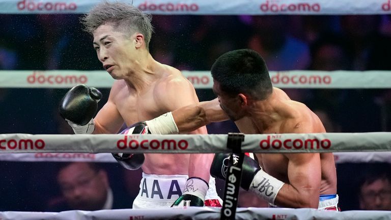 Naoya Inoue of Japan, left, is punched by Marlon Tapales of the Philippines, right, in the fifth round of their boxing match for the unified WBA, WBC, WBO and IBF super bantamweight world titles in Tokyo, Tuesday, Dec. 26, 2023. (AP Photo/Hiro Komae)