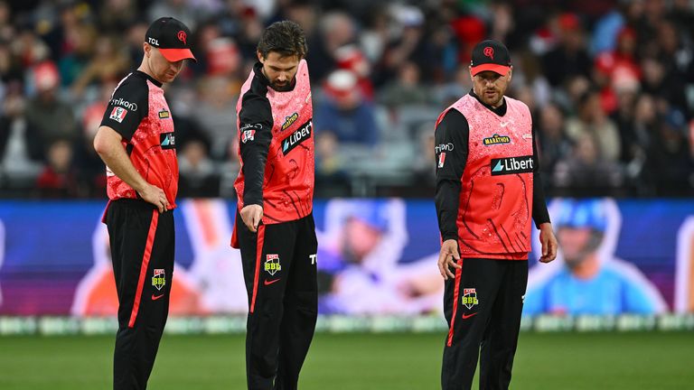 Melbourne Renegades players inspect the field before the match was cancelled