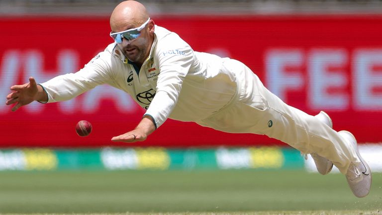 Nathan Lyon of Australia dives as attempts to field the ball during play on the third day of the first cricket test between Australia and Pakistan in Perth, Australia, Saturday, Dec. 16, 2023. (Richard Wainwright/AAP Image via AP)
