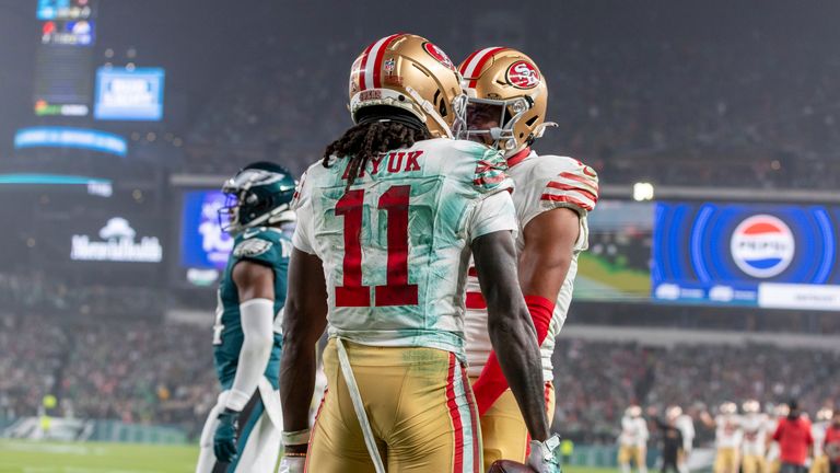 San Francisco 49ers wide receiver Brandon Aiyuk catches a touchdown pass against the Philadelphia Eagles and celebrates with teammates.