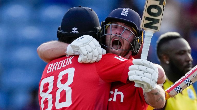 England's batsmen Harry Brook, left, and Phil Salt..celebrate defeating West Indies' by seven wickets with one ball remaining during the third T20 cricket match at National Cricket Stadium in Saint George's, Grenada, Saturday, Dec. 16, 2023. (AP Photo/Ricardo Mazalan)