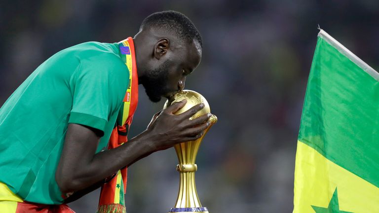 Cheikhou Kouyate จากเซเนกัลจูบถ้วยรางวัลหลังจากชนะการแข่งขันฟุตบอลแอฟริกันเนชั่นส์คัพรอบสุดท้ายปี 2022 ระหว่างเซเนกัลและอียิปต์ที่สนามกีฬา Ahmadou Ahidjo ในเมืองยาอุนเด ประเทศแคเมอรูน เมื่อวันที่ 6 กุมภาพันธ์ 2022 (AP Photo/Sunday Alamba)