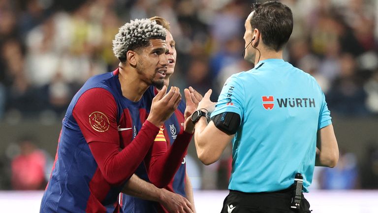 Spanish match referee Juan Martinez Munuera speaks with Barcelona's Uruguayan defender #04 Ronald Araujo and Dutch midfielder #21 Frenkie de Jong during the Spanish Super Cup final football match between Real Madrid and Barcelona at the Al-Awwal Park Stadium in Riyadh, on January 14, 2024. (Photo by Giuseppe CACACE / AFP)