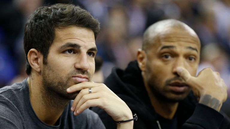 Chelsea soccer player Cesc Fabregas, left, and former Arsenal soccer player Thierry Henry, right, watch the NBA basketball game between the Milwaukee Bucks and the New York Knicks in London, Thursday, Jan. 15, 2015.