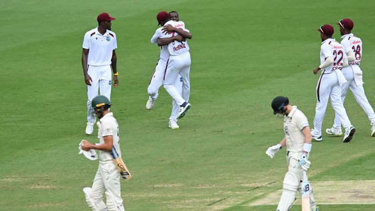 West Indies' Shamar Joseph, center, celebrates with teammates after taking the wicket of Australia's Mitchell Starc, bottom left, on the 4th day of their cricket test match in Brisbane, Sunday, Jan. 28, 2024. (Darren England/AAP Image via AP)