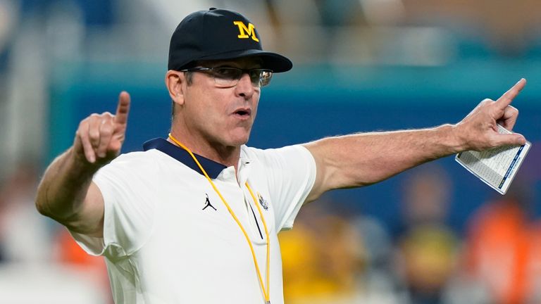 Michigan coach Jim Harbaugh gestures during warmups before the team's Orange Bowl NCAA college football playoff semifinal against Georgia, Dec. 31, 2021, in Miami Gardens, Fla. Harbaugh will be the coach of the Los Angeles Chargers, leaving Michigan after capping his ninth season as coach of college football...s winningest program with the school...s first national championship since 1997
