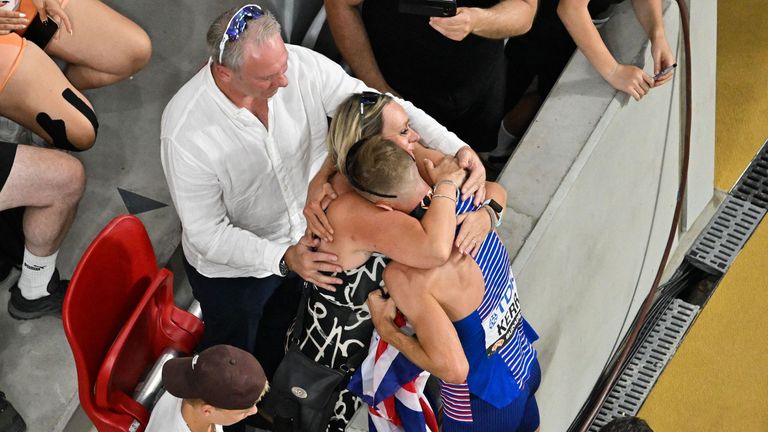 Josh Kerr with his parents in the stadium in Budapest celebrating his gold medal in the 1500m