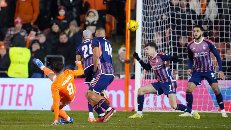 Blackpool's Albie Morgan, left, scores his side's opening goal during the English FA Cup 3rd round replay soccer match between Blackpool and Nottingham Forest at the Bloomfield Road stadium in Blackpool, England, Wednesday, Jan. 17, 2024. (AP Photo/Jon Super)