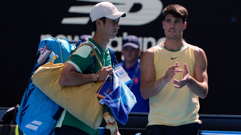 Shang Juncheng, left, of China walks from Rod Laver Arena after retiring in his third round match against Carlos Alcaraz of Spain at the Australian Open tennis championships at Melbourne Park, Melbourne, Australia, Saturday, Jan. 20, 2024. (AP Photo/Andy Wong)